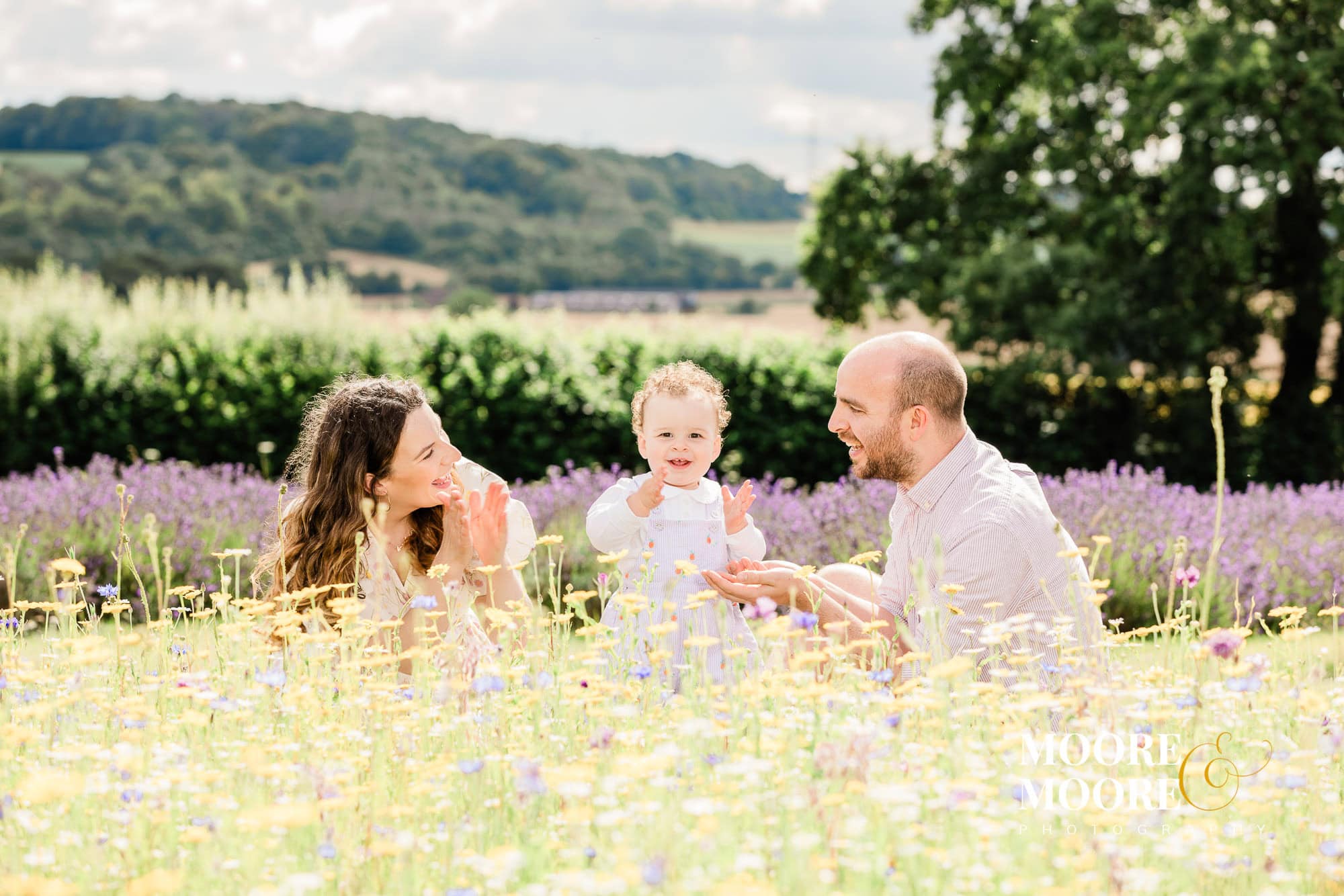 A young family enjoying the sunshine and flowers at a Lavender Fields Summertime Portraits session with Moore & Moore Photography Hampshire