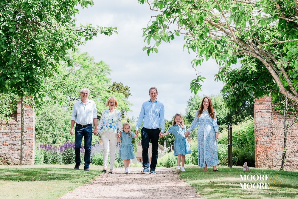 Family of four and grandparents in summer outfits during a summer portrait session in Hampshire