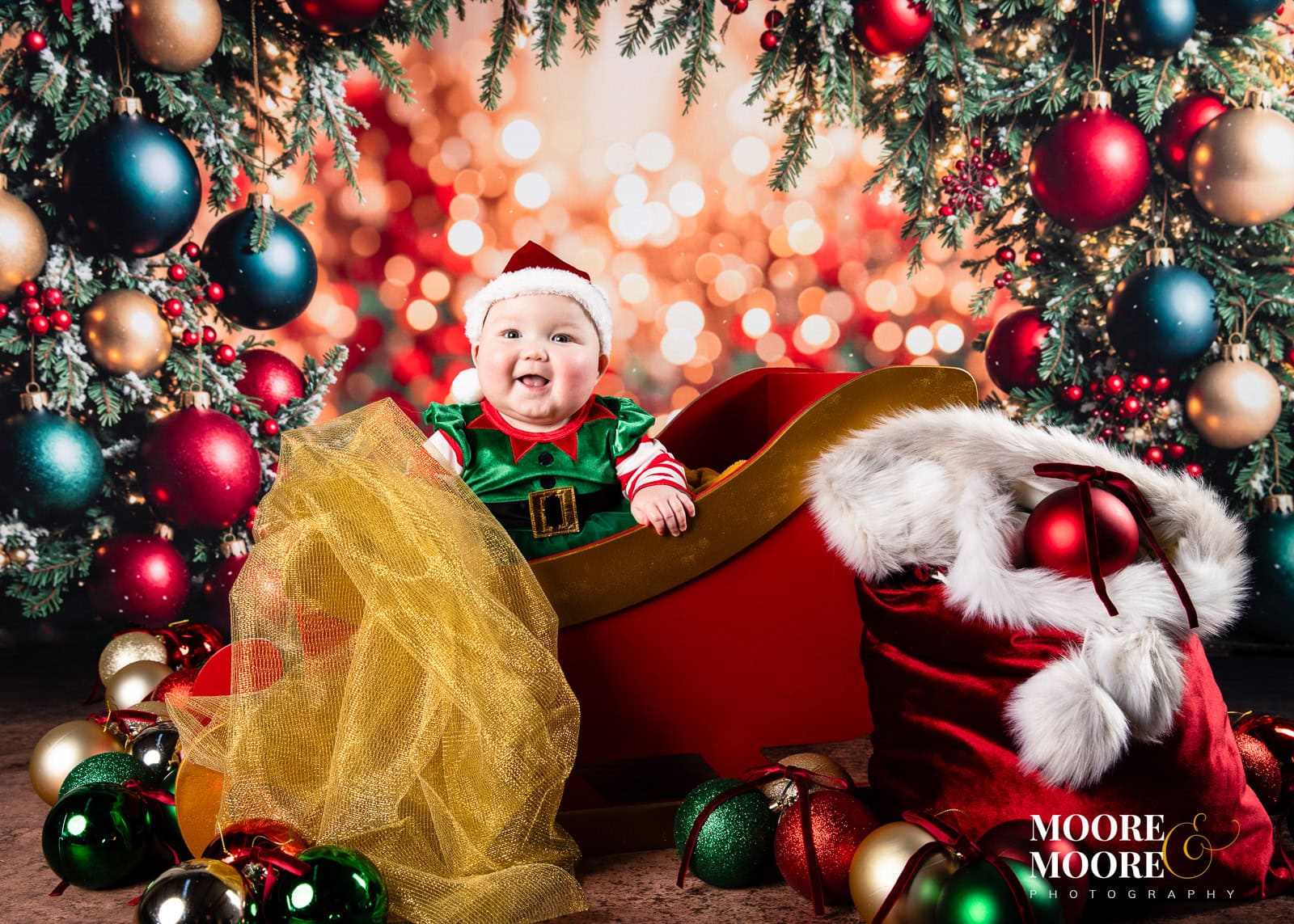 Baby's First Christmas cute photoshoot with baubles and santas baby sleigh
