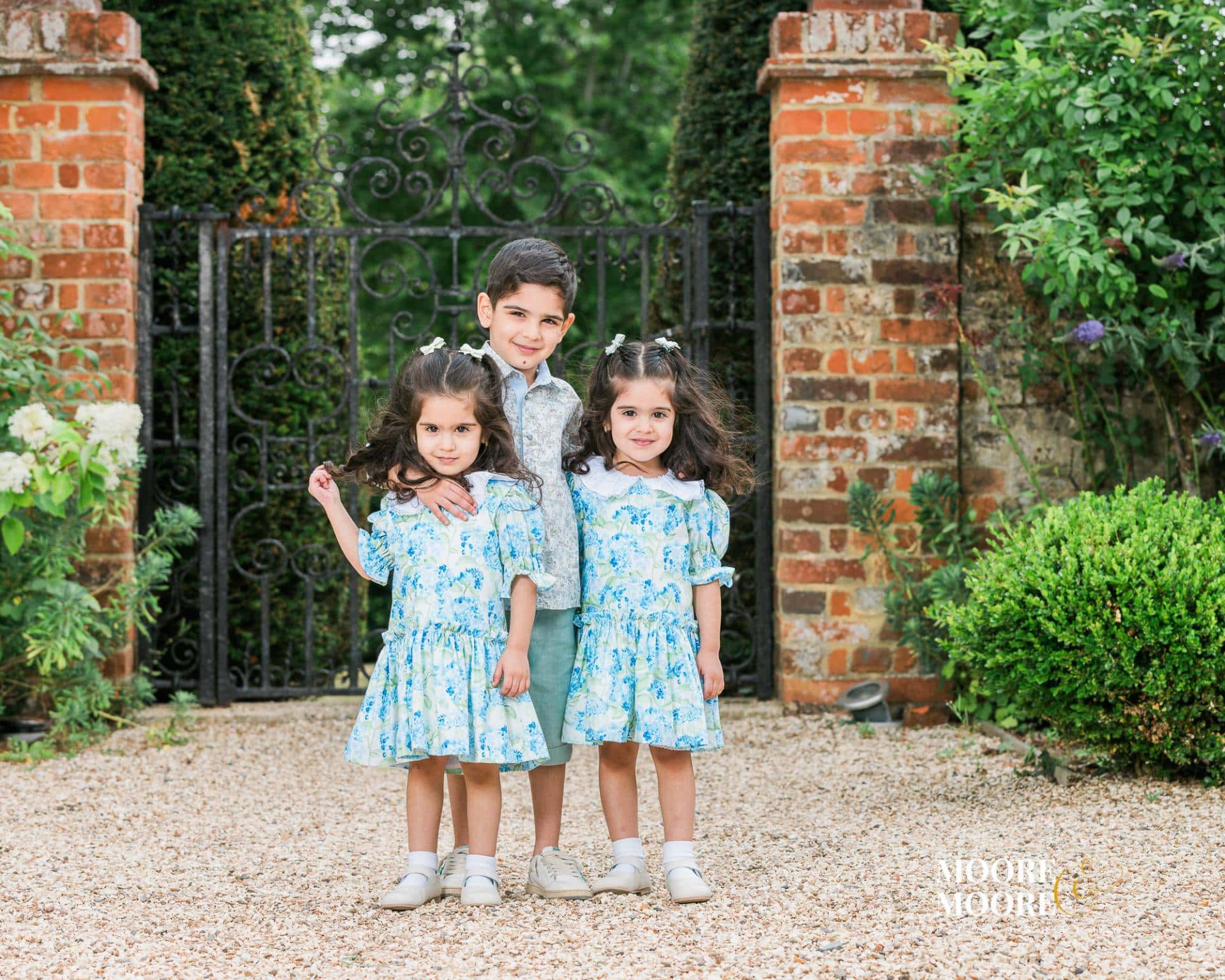 siblings-portrait-natural-connection-hampshire Three siblings standing closely together outdoors, showing confidence and natural connection during a relaxed family portrait in Hampshire.