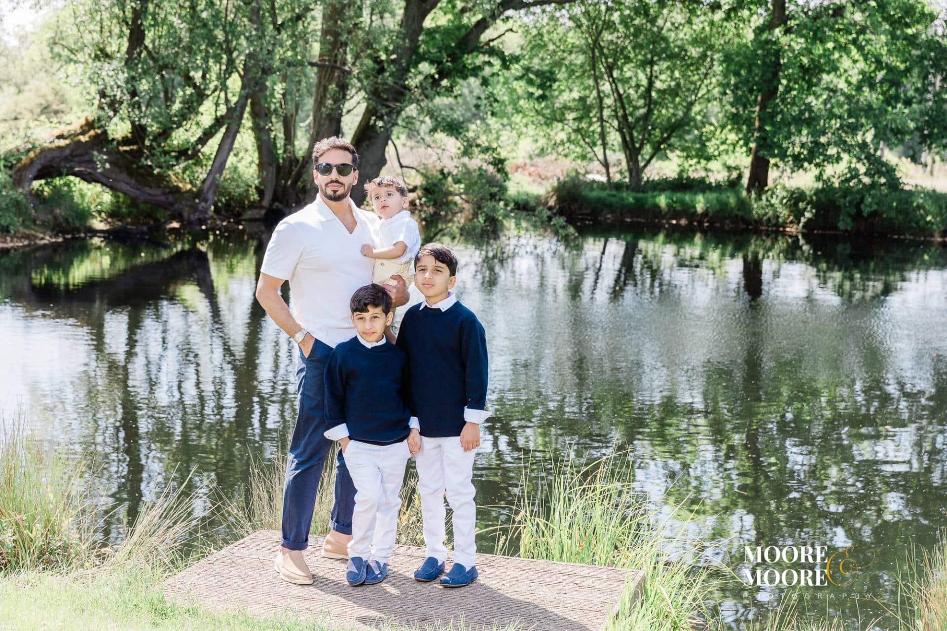 Father with his children standing by a lake during a relaxed family portrait experience in Fleet Hampshire