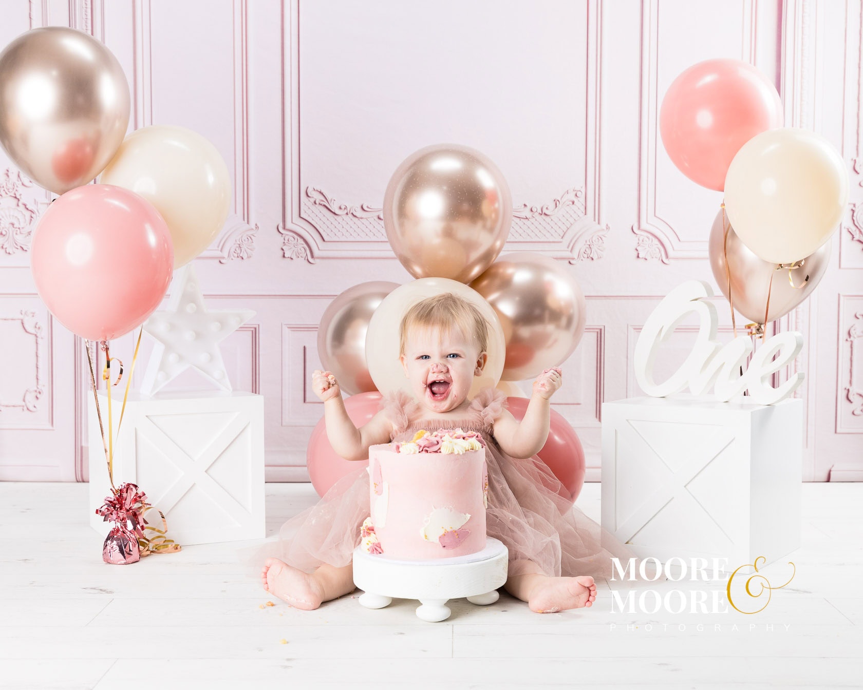Baby girl enjoying a first birthday cake smash during a calm, play-based photoshoot with a First Birthday photographer in Fleet, Hampshire
